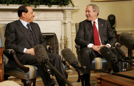President George W. Bush smiles as he and Italian Prime Minister Silvio Berlusconi meet the media in the Oval Office Tuesday, Feb. 28, 2006. The President used the occasion to commend the Prime Minister for the stability he's brought to the Italian government and to applaud his country's recent success with the Olympic Games. White House photo by Kimberlee Hewitt
