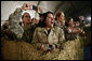 U.S. and Coalition troops cheer and take photos Wednesday, March 1, 2006, during an appearance by President George W. Bush and Mrs. Laura Bush at Bagram Air Base in Afghanistan. White House photo by Eric Draper