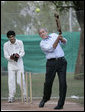 President George W. Bush watches his hit during a cricket clinic with members of the Islamabad College for Boys at the Raphel Memorial Gardens on the grounds of the U.S. Embassy in Islamabad, Pakistan. White House photo by Eric Draper