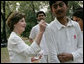 Mrs. Laura Bush signs the jerseys of students from the Schola Nova school and the Islamabad College for Boys, Saturday, March 4, 2006, who participated in a cricket clinic with President George W. Bush at the Raphel Memorial Gardens on the grounds of the U.S. Embassy in Islamabad, Pakistan. White House photo by Shealah Craighead