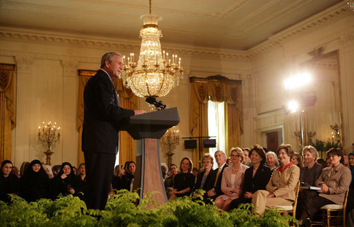 President George W. Bush joins in the celebration of International Women's Day at the White House Tuesday, March 7, 2006, as he thanks the female members of his audience for their leadership. "The struggle for women's right is a story of strong women willing to take the lead," the President told them and added, America's "a better place because of the leadership of women throughout our history." White House photo by Shealah Craighead