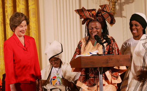 Mrs. Laura Bush reacts to remarks from Aunt Manyongo "Kunene" Mosima Tantoh, a member of the Mothers to Mothers-To-Be organization of South Africa, Monday, March 13, 2006 in the East Room at the White House. Mrs. Bush had earlier met with members of the group, who mentor and counsel mothers who come for prenatal care to clinics and find they are HIV-positive, on her visit to South Africa in July of 2005. Group member Gloria Ncanywa is seen at right. White House photo by Shealah Craighead