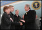 President George W. Bush greets Greece Athena High School senior, Jason McElwain and McElwain's mother, Debbie, upon arriving in Rochester, New York Tuesday, March 14, 2006. After serving as the team's manager McElwain, who is autistic, was called on to play during the team's last game of the season. McElwain became a local hero after he sank six 3-point shots during the last moments of his first ever varsity basketball game. White House photo by Kimberlee Hewitt