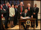 President George W. Bush signs the H.R. 32, the Stop Counterfeiting in Manufactured Goods Act, during ceremonies Thursday, March 16, 2006, in the Eisenhower Executive Office Building. Looking on are, from left: Secretary Carlos Gutierrez, Department of Commerce; Secretary Elaine Chao, Department of Labor; Attorney General Alberto Gonzales; U.S. Rep. Jim Sensenbrenner (R-Wis.); U.S. Rep.Joe Knollenberg (R-Mich.), and U.S. Rep. Bobby Scott (D-Va.). White House photo by Kimberlee Hewitt