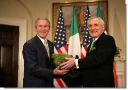 President George W. Bush is presented a bowl of shamrocks by Prime Minister Bertie Ahern of Ireland, during a ceremony Friday, St. Patrick's Day 2006, in the Roosevelt Room of the White House.  White House photo by Kimberlee Hewitt