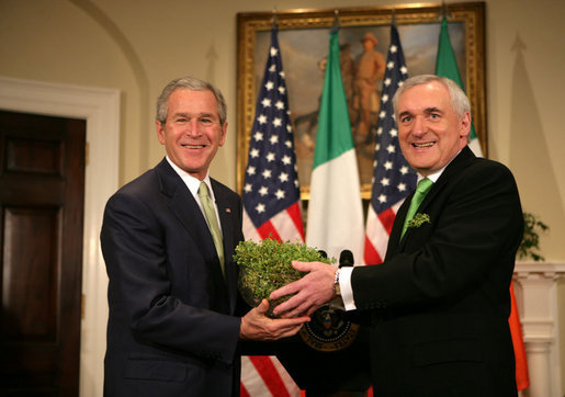 President George W. Bush is presented a bowl of shamrocks by Prime Minister Bertie Ahern of Ireland, during a ceremony Friday, St. Patrick's Day 2006, in the Roosevelt Room of the White House. White House photo by Kimberlee Hewitt