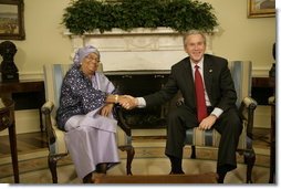 President George W. Bush welcomes Liberia's President Ellen Johnson Sirleaf to the Oval Office at the White House, Tuesday, March 21, 2006. President Sirleaf is the first woman elected President to any country on the continent of Africa.  White House photo by Eric Draper