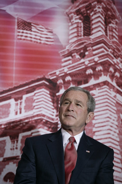 President George W. Bush stands before a backdrop of Ellis Island, Monday, March 27, 2006, at the Naturalization Ceremony for new U.S. citizens at the Daughters of the American Revolution Administration Building in Washington. President Bush welcomed the new U.S. citizens, telling them that each generation of immigrants brings a renewal to our national character and adds vitality to our culture. White House photo by Eric Draper