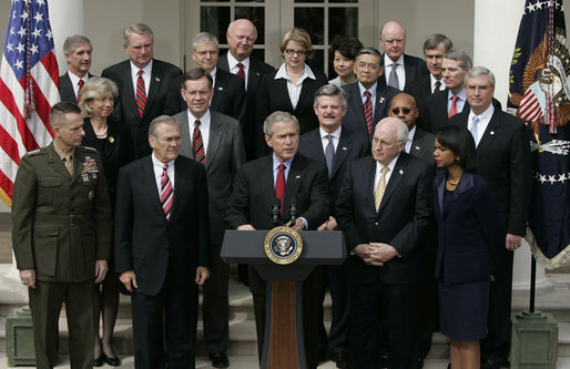 Flanked by members of the Cabinet, President George W. Bush delivers remarks to the media during a press conference Tuesday, March 28, 2006, in the Rose Garden of the White House. White House photo by Paul Morse