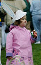 A young child wears her bunny hat and enjoys some candy while strolling the South Lawn of the White House during the 2006 White House Easter Egg Roll, Monday, April 17, 2006. White House Photo by Julie Kubal 