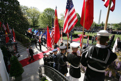 Flags are raised high as President George W. Bush and Mrs. Laura Bush make their way from the White House South Portico to participate in the South Lawn Arrival Ceremony for Chinese President Hu Jintao, Thursday, April 20, 2006. White House photo by David Bohrer