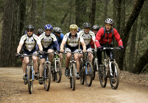 President George W. Bush rides with the Travis Air Force Base cycling team in the Los Posados State Forest, in Angwin, California, Saturday, April 22, 2006. White House photo by Eric Draper