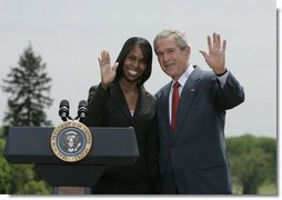 President George W. Bush and Kim Oliver, the 2006 National Teacher of the Year, wave from the podium on the South Lawn Wednesday, April 26, 2006, during a ceremony honoring the Silver Spring, Maryland kindergarten teacher.  White House photo by Paul Morse