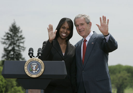 President George W. Bush and Kim Oliver, the 2006 National Teacher of the Year, wave from the podium on the South Lawn Wednesday, April 26, 2006, during a ceremony honoring the Silver Spring, Maryland kindergarten teacher. White House photo by Paul Morse
