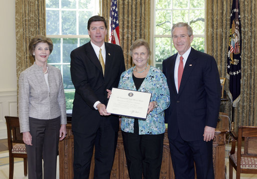 President George W. Bush and Mrs. Bush present the Preserve America award for heritage tourism to Dennis Castleman, Assistant Secretary for Tourism, Film, and the Arts, Maryland Department of Business and Economic Development, and Audrey Scott, Secretary of Planning, Maryland Department of Planning, in the Oval Office Monday, May 1, 2006. White House photo by Eric Draper
