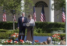 Mrs. Laura Bush and President George W. Bush address guests in the Rose Garden during an event honoring the recipients of the Preserve America Presidential Awards May 1, 2006.  White House photo by Kimberlee Hewitt
