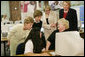 Mrs. Laura Bush and U.S. Department of Education Secretary Margaret Spellings, center, look at computer information with St. Boniface sixth-graders and senior citizens Tuesday, May 2, 2006 in Ft. Smith, Ark., to remind seniors of the May 15th enrollment deadline to sign-up for the Medicare Prescription Drug Benefit. White House photo by Shealah Craighead