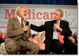 President George W. Bush speaks with retired senior Peter Navarro during A Conversation on the Medicare Prescription Drug Benefit at the Asociacion Borinquena de Florida Central, Inc., in Orlando Wednesday, May 10, 2006. White House photo by Eric Draper