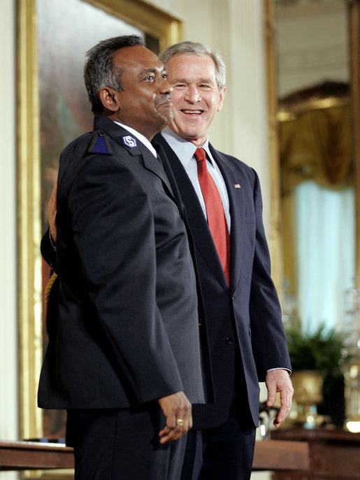 President George W. Bush and Durai Pandithurai of Cedar Hill, Texas, stand together for the presentation of the President's Volunteer Service Award in the East Room Friday, May 12, 2006. "The volunteers we recognize have brought care and outreach to veterans and men and women in uniform; they've helped children learn to read; they've extended food and shelter to hurricane victims in our Gulf Coast; they've helped underprivileged high school students prepare their SATs; and they've aided immigrants who have recently arrived in our country. They have served our nation in distinct ways, and in so doing have made America a better place to live," said the President. White House photo by Paul Morse
