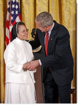 President George W. Bush awards Sister Theresa Pham of Houston with the President's Volunteer Service Award during an event celebrating Asian Pacific American Heritage Month in the East Room Friday, May 12, 2006. "I created this award because I understand the great strength of the United States of America is not found in our military, and it's certainly not because of the size of our wallets, it's because the strength of America is found in the hearts and souls of generous citizens who answer to a universal call to love a neighbor like you'd like to be loved yourself," said the President White House photo by Paul Morse