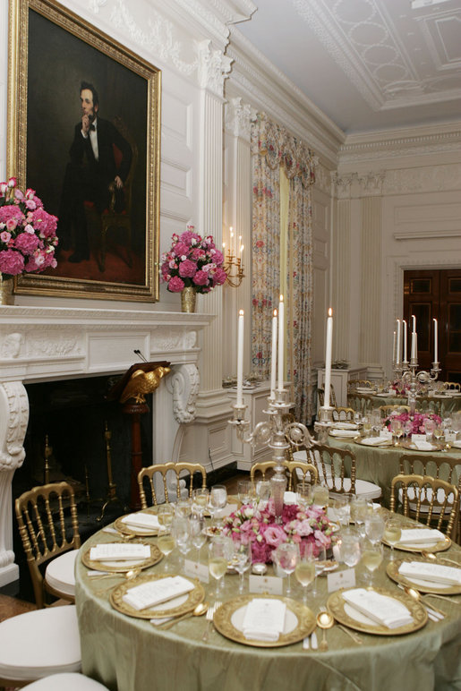 A portrait of President Abraham Lincoln is seen above the fireplace in the State Dining Room of the White House, as tables are set and decorated Tuesday, May 16, 2006, for the official dinner to honor Australian Prime Minister John Howard and his wife Janette Howard. White House photo by Shealah Craighead