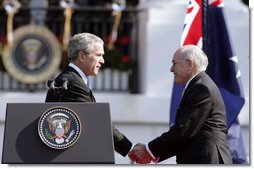 After delivering his remarks, President George W. Bush shakes hands with Australian Prime Minister John Howard during the State Arrival Ceremony held for the Prime Minister on the South Lawn Tuesday, May 16, 2006. "Freedom has enemies, and for more than a hundred years, Australians and Americans have joined together to defend freedom," said President Bush. "Together we fought the Battle of Hamel in World War I. Together we fought in World War II from the beaches of Normandy to the waters of the Coral Sea. Together we fought in Korea and Vietnam. And together we're fighting, and winning, the global war on terror."  White House photo by Paul Morse
