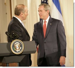 President George W. Bush and Prime Minister Ehud Olmert of Israel exchange handshakes Tuesday, May 23, 2006, at the end of a joint press availability in the East Room of the White House. White House photo by Eric Draper