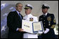 President George W. Bush presents Admiral Tom Collins, center, and Master Chief Petty Officer Frank Welch with the Presidential Unit Citation, Thursday, May 25, 2006 at Fort Lesley J. McNair in Washington, D.C., during the Change of Command Ceremony for the Commandant of the United States Coast Guard. White House photo by Eric Draper