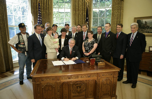 President George W. Bush is joined by Congressman Steve Buyer, R-IN, second from left, Congressman Mike Rogers, R-MI, center background, Senator Bill Frist, R-TN, right, Senator John Warner, R-Va, far right, members of the Patriot Guard Riders and family members of fallen soldier, Sergeant Rickey Jones who was killed in Iraq, as he signs H.R. 5037, the Respect for America's Fallen Heroes Act, Monday, May 29, 2006. White House photo by Paul Morse