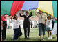 Mrs. Laura Bush participates in playing with a colorful parachute with children and staff outside the Meadowbrook Collaborative Community Center, Tuesday, June 6, 2006 in St. Louis Park. Minn. White House photo by Shealah Craighead