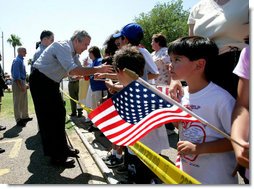 President George W. Bush greets a crowd during an unscheduled stop at a Laredo, Texas, elementary school after visiting the Laredo Border Patrol Sector Headquarters, Tuesday, June 6, 2006. White House photo by Eric Draper