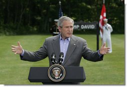 President George W. Bush gestures as he answers a reporter's question during his joint news conference with Prime Minister Anders Fogh Rasmussen of Denmark at Camp David Friday, June 9, 2006. White House photo by Eric Draper