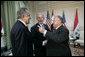 President George W. Bush shakes hands with Iraqi President Jalal Talabani, right, during his visit Tuesday, June 13, 2006, to the U.S. Embassy in Baghdad. With them is U.S. Ambassador to Iraq Zalmay Khalilzad. White House photo by Eric Draper