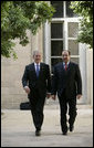 President George W. Bush walks with Prime Minister Nouri al-Maliki Tuesday, June 13, 2006, at the U.S. Embassy in Baghdad, Iraq. During his unannounced trip to Iraq, President Bush thanked the Prime Minister, telling him, "I'm convinced you will succeed, and so will the world." White House photo by Eric Draper