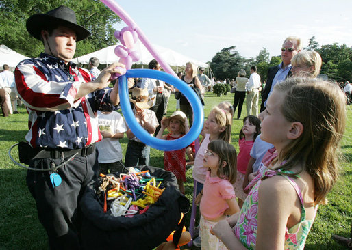 Children attending the annual Congressional Picnic on the South Lawn of the White House Wednesday evening, June 15, 2006, are enthralled as they watch a cowboy balloon artist. White House photo by Kimberlee Hewitt