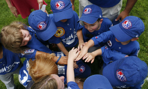 Teammates of the Dolcom Little League Indians of the Naval Submarine Base of Groton, Ct., huddle together for a cheer during the opening Tee Ball game of the 2006 season on the South Lawn of the White House, Friday, June 23, 2006, between the Dolcom Indians and the McGuire AFB Little league Yankees. White House photo by Paul Morse