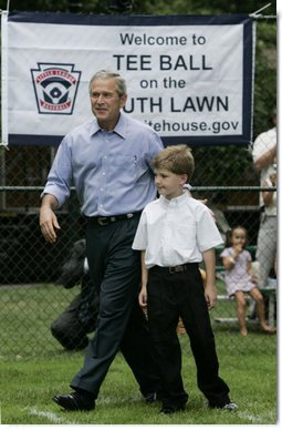 President George W. Bush joins Zane Ellingwood, the First Ball Presenter, on the South Lawn of the White House at the opening game of the 2006 Tee Ball season, Friday, June 23, 2006, between the McGuire Air Force Base Little League Yankees and the Dolcom Little League Indians of the Naval Submarine Base from Groton, Ct.  White House photo by Paul Morse