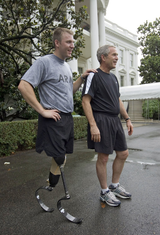 President George W. Bush and U.S. Army Staff Sergeant Christian Bagge, 23, of Eugene, Ore., talk with the media after their run on the South Lawn Tuesday, June 27, 2006. White House photo by Eric Draper
