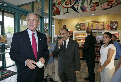President George W. Bush offers to buy a cup of coffee for a member of the media during a stop at Dunkin' Donuts in Alexandria, Va., July 5, 2006. "We need to make sure we help people assimilate. I met four people here who assimilated into our country. They speak English; they understand the history of our country; they love the American flag as much as I love the American flag," said the President. "That's one of the great things about America, we help newcomers assimilate. Here's four folks that are living the American Dream, and I think it helps renew our soul and our spirit to help people assimilate." White House photo by Kimberlee Hewitt