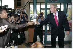 President George W. Bush offers to buy a cup of coffee for a member of the media during a stop at Dunkin' Donuts in Alexandria, Va., July 5, 2006, where President Bush spoke in support of the Basic Pilot Program to verify employment eligibility. White House photo by Kimberlee Hewitt