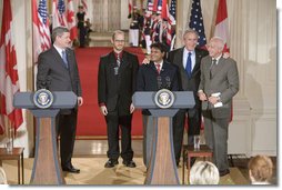 After holding a press conference with Canadian Prime Minister Stephen Harper, President George W. Bush poses with fellow birthday celebrants in the East Room Thursday, July 6, 2006. The President celebrates his 60th birthday today. Pictured with him are, from left. Todd Mizis of the U.S. State Department; Raghubir Goyal of the India Globe and Asia Today; and Richard Benedetto of USA Today.  White House photo by Kimberlee Hewitt