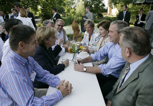 President George W. Bush shares a conversation with Chancellor Angela Merkel of Germany as he and Mrs. Laura Bush enjoy a barbeque dinner in Trinwillershagen as guests of the Chancellor. White House photo by Eric Draper