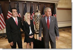 President George W. Bush meets with Sam Hornish Jr., the 2006 winner of the Indianapolis 500, and his wife, Crystal Hornish, as they stand next to the 500 race Borg-Warner Trophy Tuesday, July 18, 2006, at the Eisenhower Executive Office Building in Washington. White House photo by Eric Draper