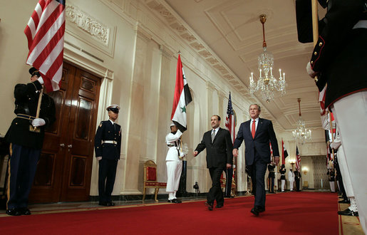 President George W. Bush and Iraqi Prime Minister Nouri al-Maliki walk through the Cross Hall to the East Room where the two leaders held a joint press conference Tuesday, July 25, 2006. "You have a strong partner in the United States of America, and I'm honored to stand here with you, Mr. Prime Minister," said President Bush. "It's a remarkable and historical moment, as far as I'm concerned, to welcome the freely elected leader of Iraq to the White House." White House photo by Kimberlee Hewitt
