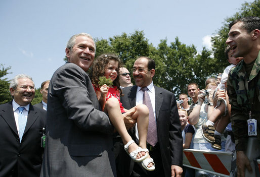 President George W. Bush and Iraqi Prime Minister Nouri al-Maliki pose for a photo with five-year-old Isabelle Colletti during their visit Wednesday, July 26, 2006 to Fort Belvoir, Va., where they met with military personnel and their families. White House photo by Paul Morse