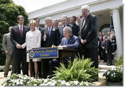 President George W. Bush is joined by Senate and House members as he signs H.R. 4472, the Adam Walsh Child Protection and Safety Act of 2006 at a ceremony Thursday, July 27, 2006, in the Rose Garden at the White House, as John Walsh, center, and his wife, Reve Walsh, look on. The bill is named for the Walsh’s six-year-old son Adam Walsh who was abducted and killed 25 years ago.  White House photo by Eric Draper