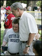 President George W. Bush embraces a South Lawn buddy volunteer Sunday, July 30, 2006, on the South Lawn of the White House at the conclusion of the Tee Ball on the South Lawn game between the Thurmont Little League Civitan Club of Frederick Challengers of Thurmont, Md., and the Shady Spring Little League Challenger Braves of Shady Spring, W. Va. White House photo by Paul Morse