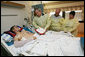 President George W. Bush awards a Purple Heart medal and citation to U.S. Marine Lance Cpl. Patrick Howard of Windermere, Fla., Tuesday, Aug. 1, 2006, at the National Naval Medical Center in Bethesda, Md., as Howard's parents Bertha and Wally Howard look on. Howard is recovering from wounds suffered in Operation Iraqi Freedom. White House photo by Eric Draper