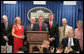 Accompanied by seven White House Press Secretaries, President George W. Bush jokes with reporters Wednesday, August 2, 2006, during the last day of operation of the James S. Brady Press Briefing Room before it undergoes a renovation. On stage with the President are, from left: Joe Lockhart, Dee Dee Myers, Marlin Fitzwater, Tony Snow, Ron Nessen, James Brady and his wife Sarah Brady. White House photo by Shealah Craighead