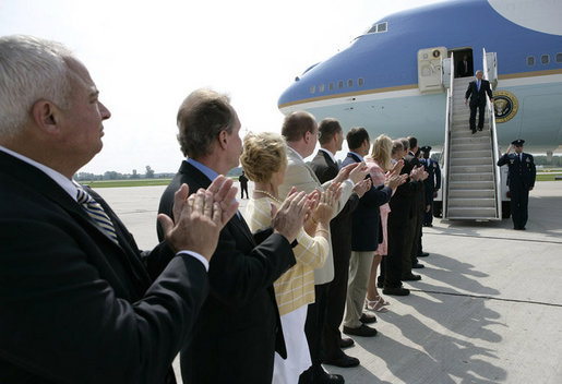 President George W. Bush is applauded by a welcoming committee of state and local community leaders as he arrives at Austin Straubel International Airport in Green Bay, Wis., Thursday, Aug. 10, 2006. After greeting the welcoming committee President Bush spoke to reporters on the airline bombing plot uncovered in the United Kingdom, saying it is "a stark reminder that this nation is at war with Islamic fascists who will use any means to destroy those of us who love freedom, to hurt our nation." White House photo by Eric Draper